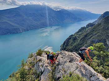 Bildet viser deltakere som klatrer Via Ferrata ved Gardasjøen.