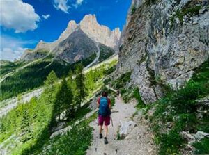 Lite bilde av Deltaker med staver på smal sti i Dolomittene